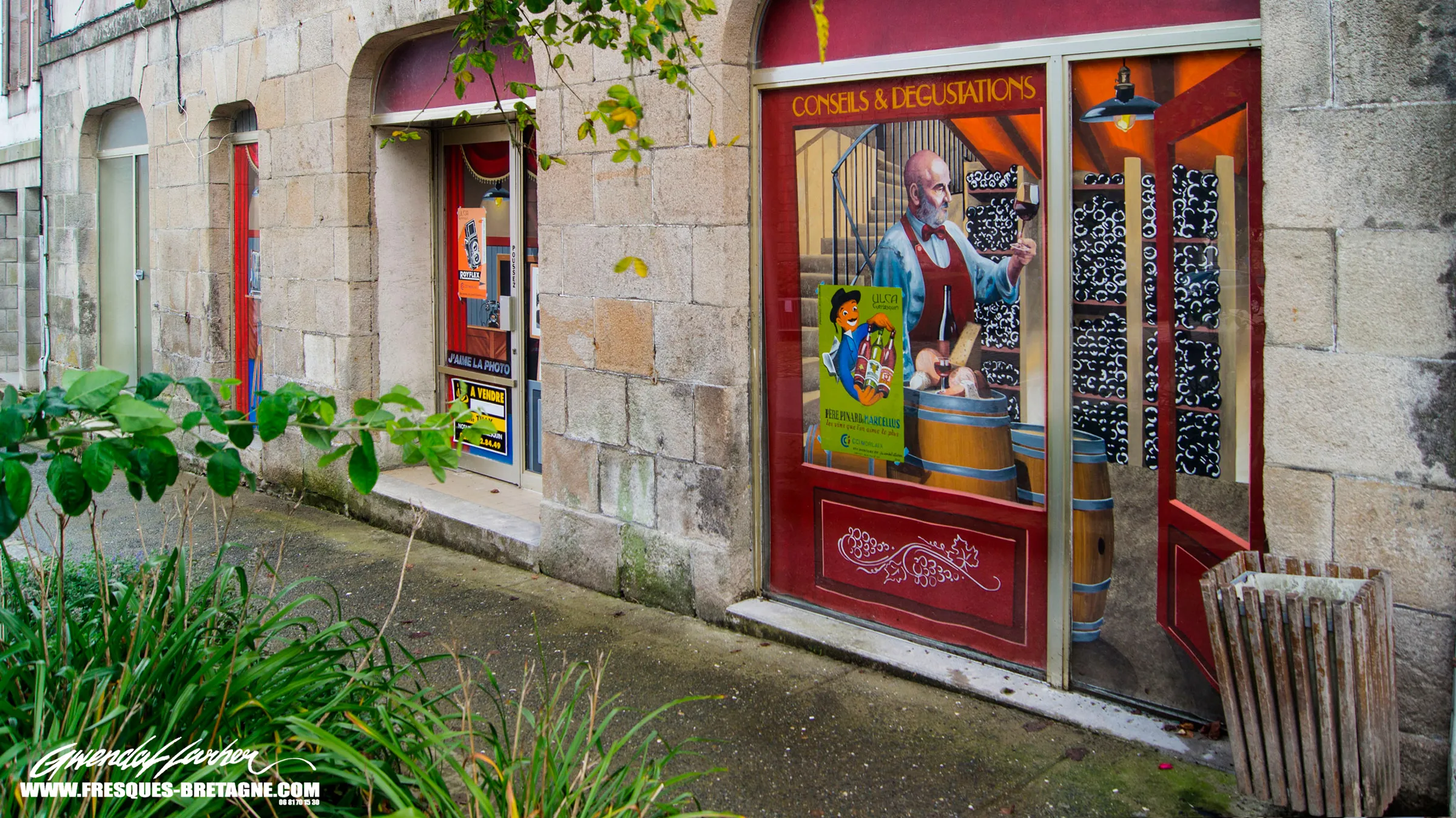 Faux caviste peint en trompe-l'œil sur une vitrine de commerce à Guerlesquin